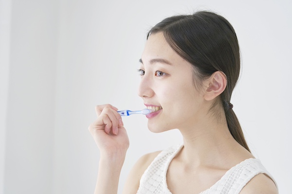 ホワイトニングと食生活 白く美しい歯を保つため避けたい食品｜渋谷マロン歯科Tokyo｜歯磨きで歯のケアをする女性